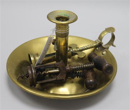 A brass candle holder and two various cork screws